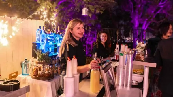 a bartender serving a cocktail and having conversation with guest | bartenders to hire | Party Shakers
