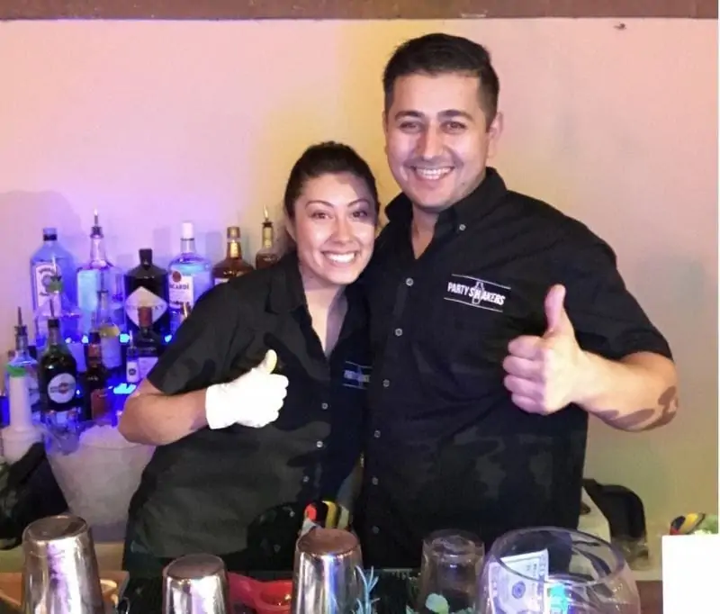 Male and female bartenders behind a full set up bar | Party Shakers professional bartender tips
